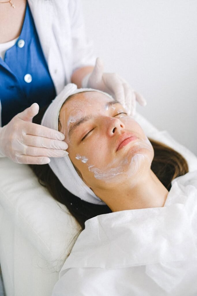 Woman receiving a facial treatment at a spa, promoting skin health and relaxation.